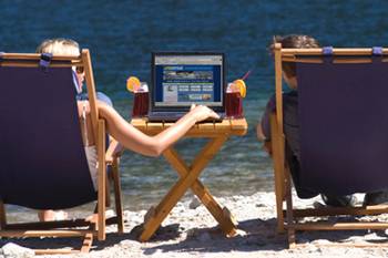 Using a computer on the beach Using a computer on the beach